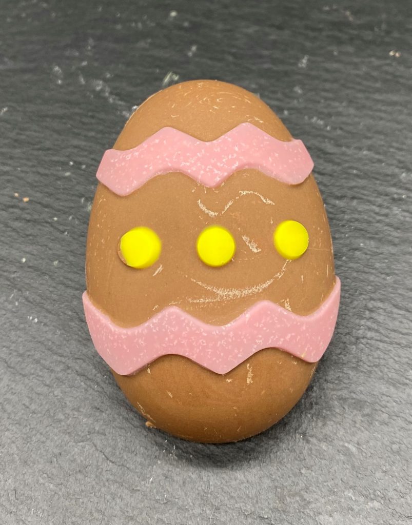 chocolate egg with stripes in pink and yellow dots